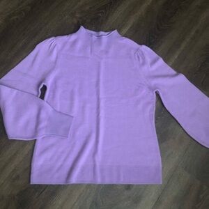 New! A pretty neckline and sleeves elevate this must-have  sweater.